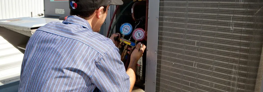 HVAC technician servicing a condenser unit in Summerville