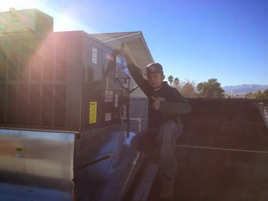 HVAC technician performing AC Tune-Up on a rooftop unit in Summerville